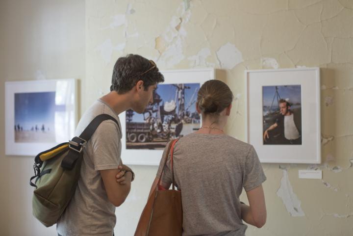 A couple examining a photo on display at a gallery.