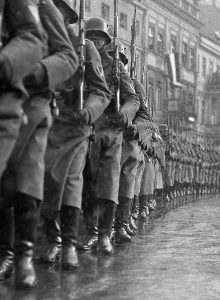 Rows of Nazi soldiers marching through the rain. 