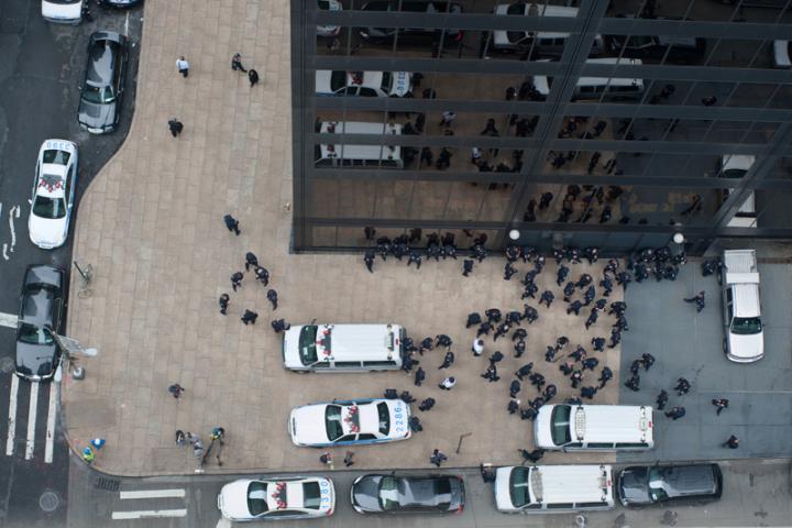 An aerial view of cops protecting a skyscraper. 