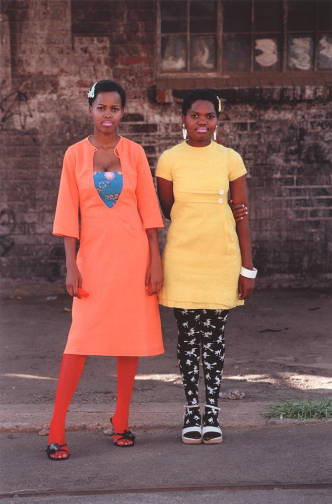 Two young teenage girls in colorful outfits. 