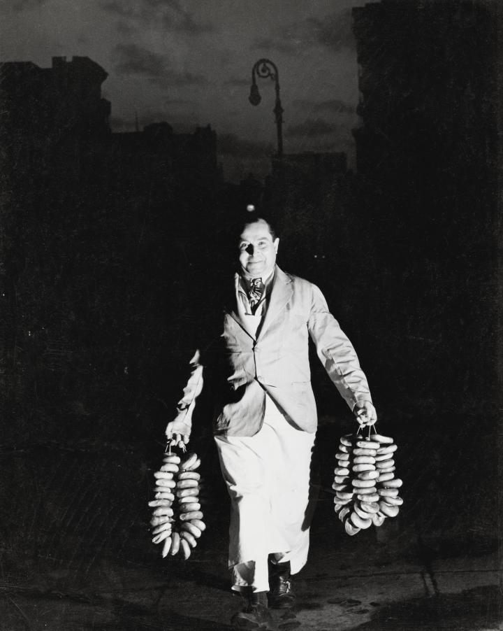 Old image of a man holding a ring of bagels