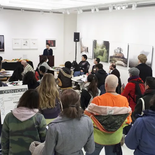 A photo of a group of people watching a presentation.