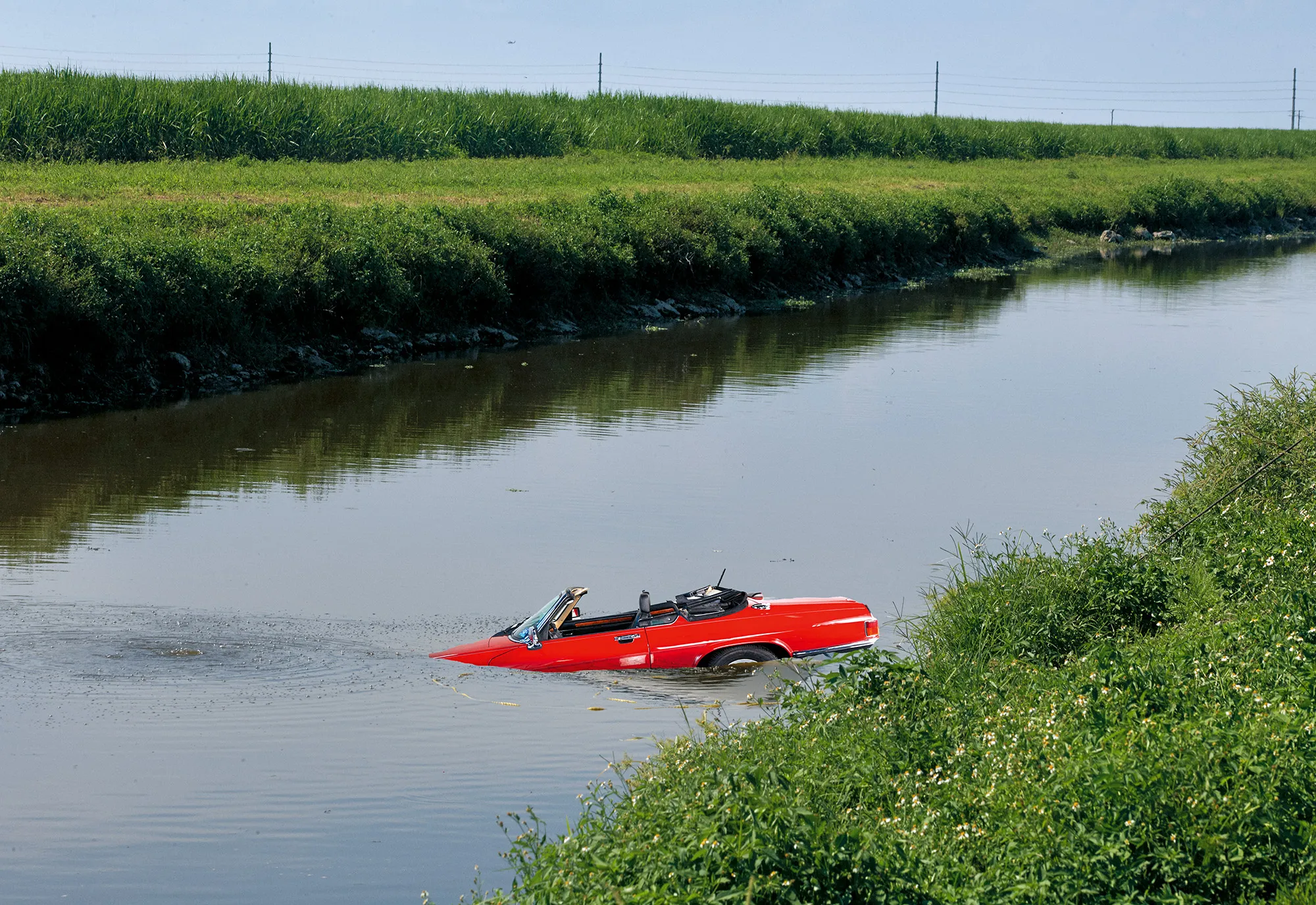 A car lays submerged in a river.