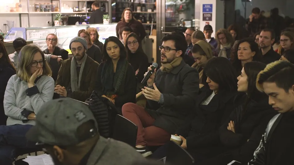 A man talking into a mic from the crowd.