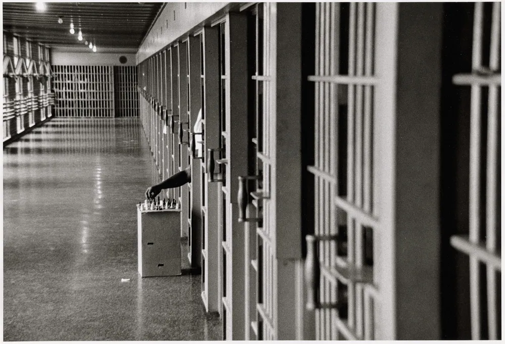 A man playing chess in jail.