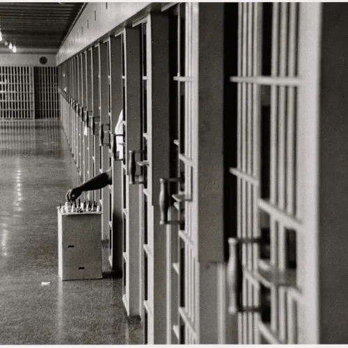 A picture of a guy playing chess in jail.