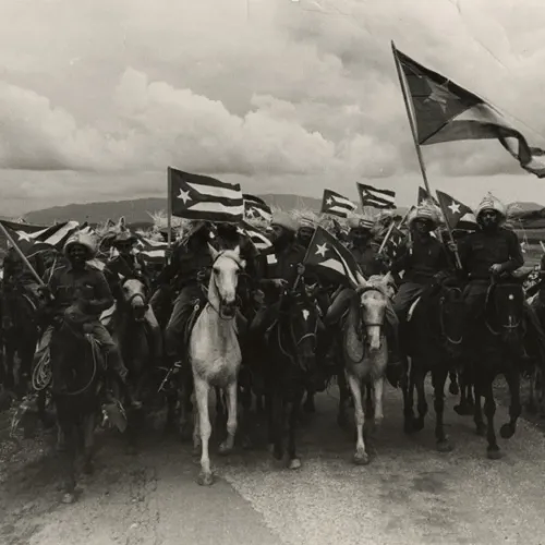 A group of soldiers on their horses waving their national flag.