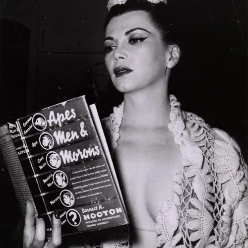 A woman reading a book titled, "Apes, Men, and Morons."