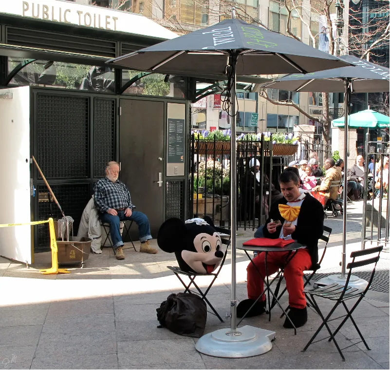 A man in a mickey mouse costume sitting down.