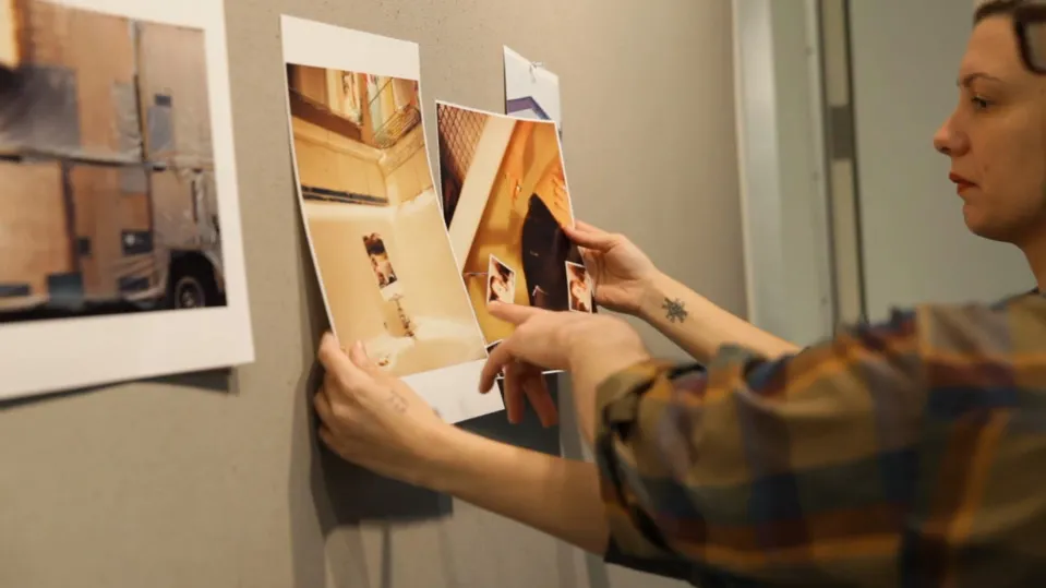 A person hanging art to the wall.