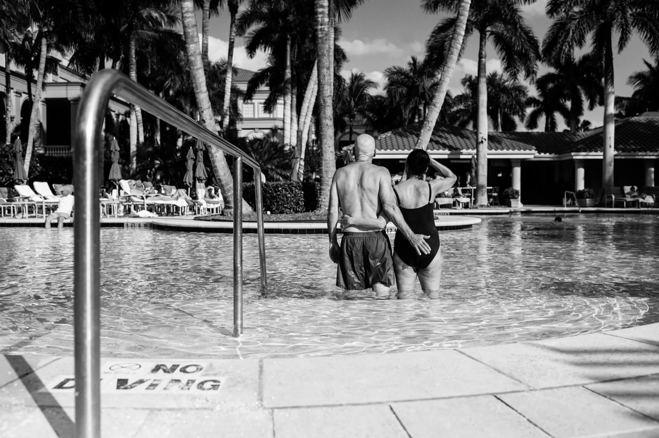 A couple going into a pool.