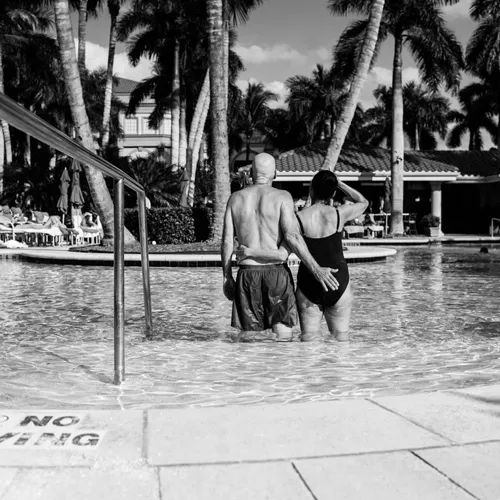 A couple going into a pool.