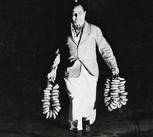 Old image of a man holding a ring of bagels