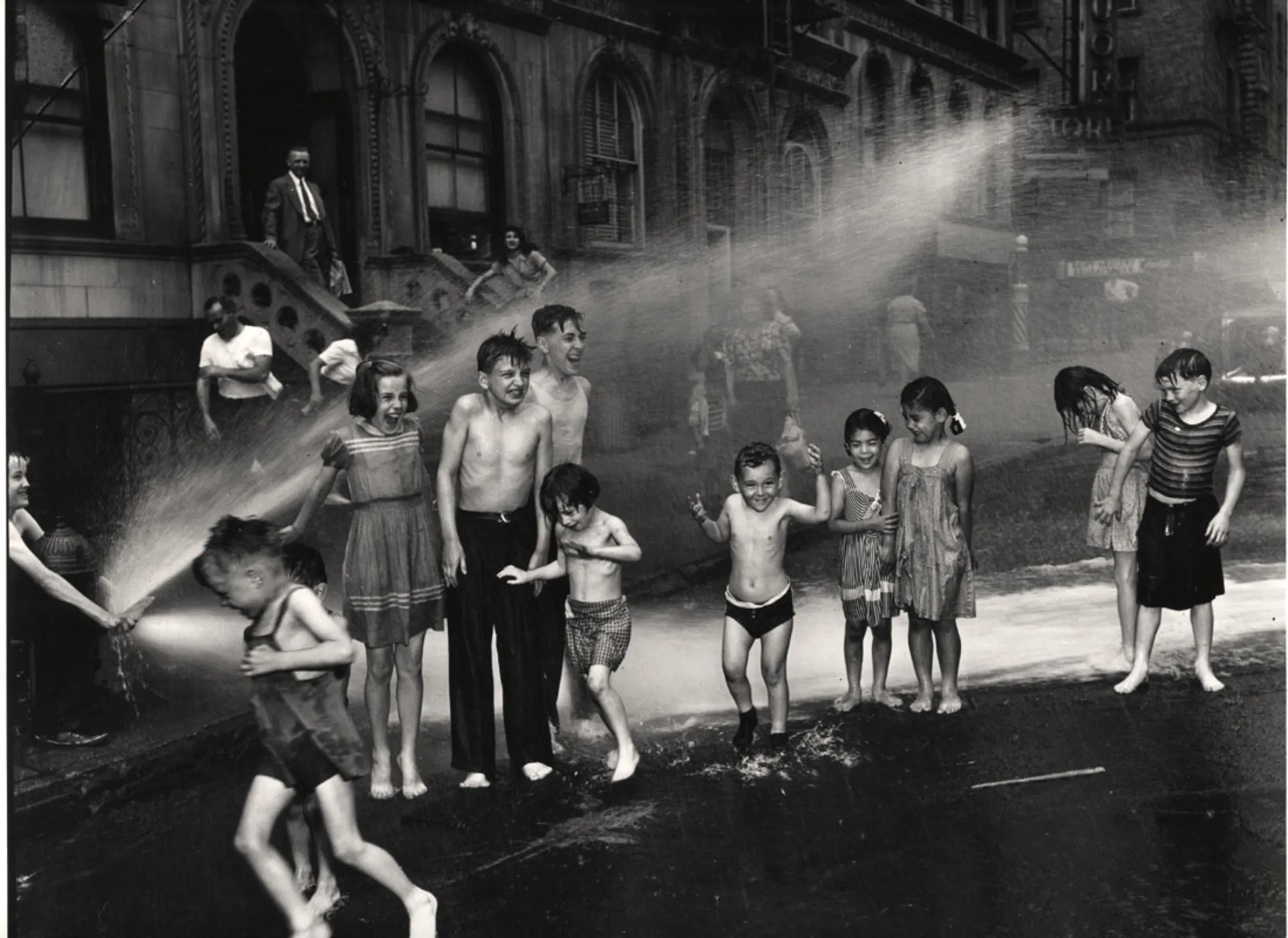A black and white photo of kids playing in the streets. 